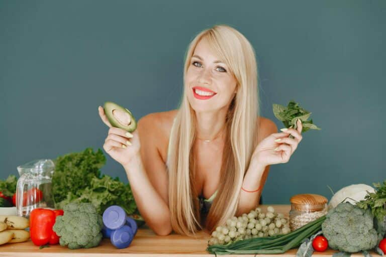 Une femme qui montre des légumes sur une table